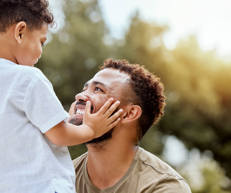 Kleiner Sohn berührt seinen Vater mit den Händen.
