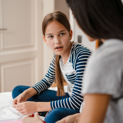 Mutter-Tochter-Gespräch Mutter und Tochter sitzen auf dem Bett und sprechen miteinander.