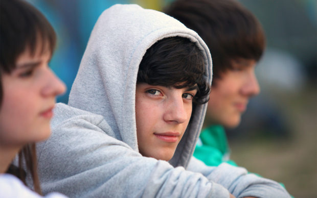 Jugendlicher mit grauem Kapuzenpullover 